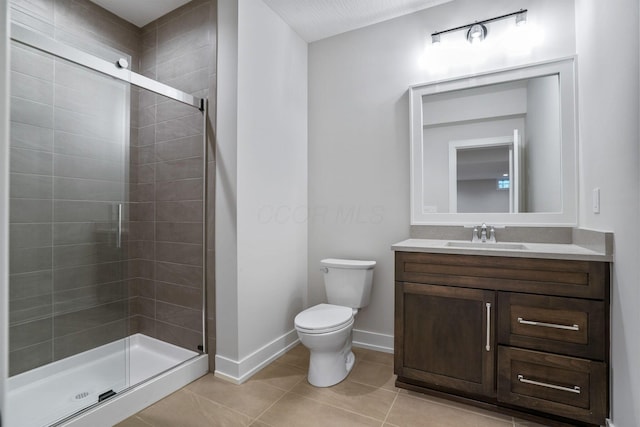 full bathroom featuring baseboards, toilet, tile patterned floors, vanity, and a shower stall