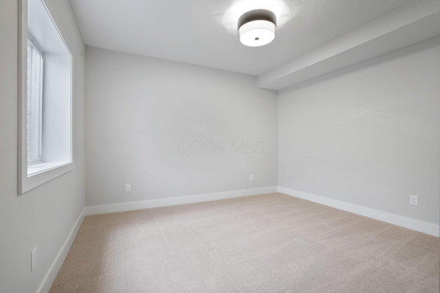 empty room featuring carpet flooring and baseboards