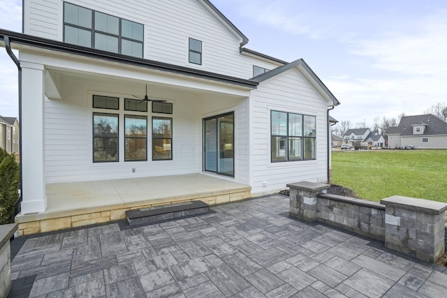 rear view of house featuring a patio, a lawn, and a ceiling fan