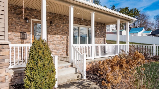 view of exterior entry featuring covered porch