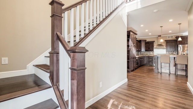 staircase featuring crown molding and hardwood / wood-style flooring