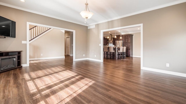 unfurnished living room featuring ornamental molding and dark wood-type flooring