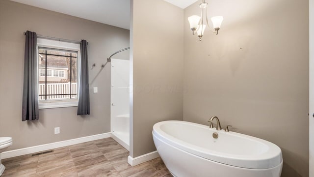 bathroom with plus walk in shower, toilet, and a notable chandelier