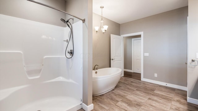 bathroom with separate shower and tub and a chandelier