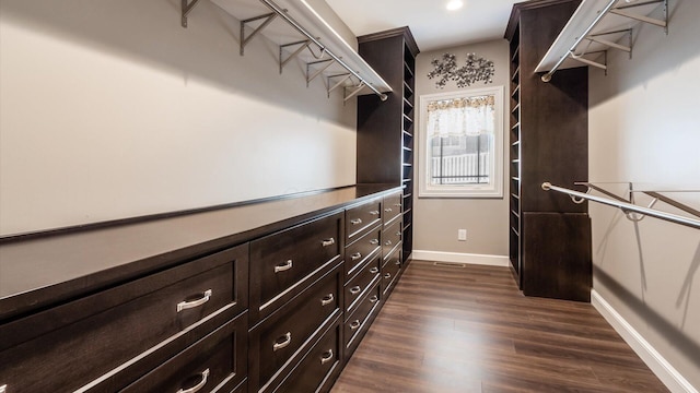 walk in closet with dark hardwood / wood-style floors