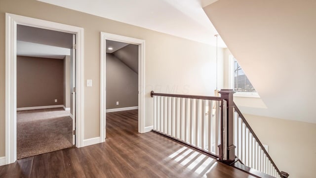 hall with vaulted ceiling and hardwood / wood-style flooring