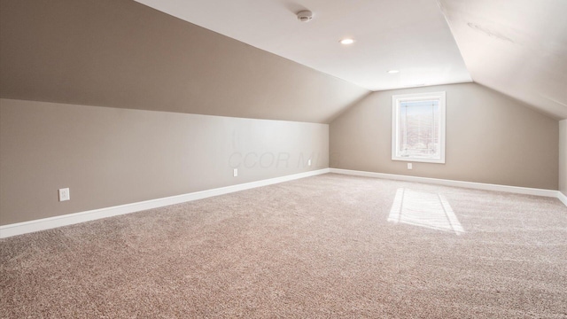 additional living space featuring carpet flooring and lofted ceiling