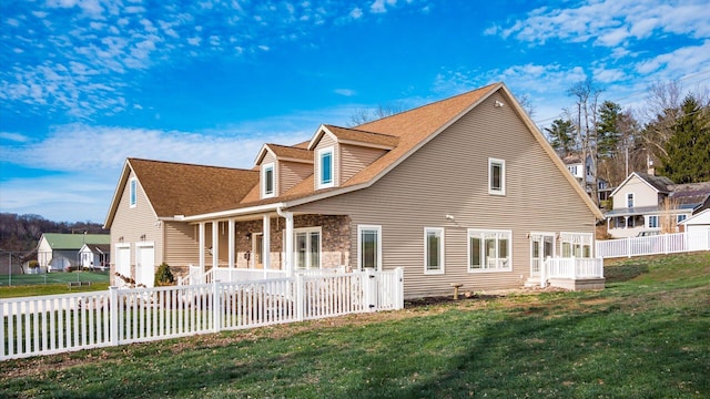 rear view of house with a yard and a garage