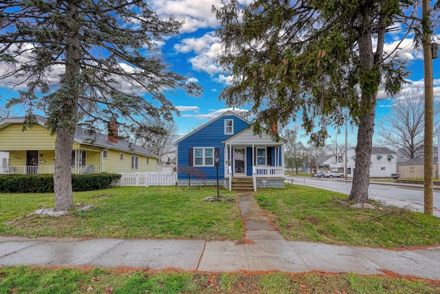 bungalow with covered porch and a front yard