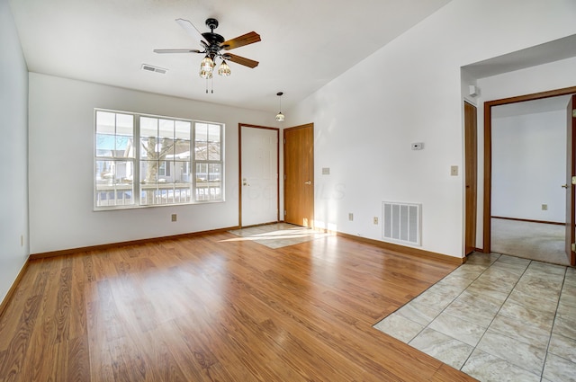 spare room featuring ceiling fan, light hardwood / wood-style floors, and lofted ceiling