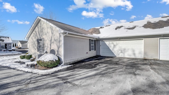 view of home's exterior with a garage and central AC