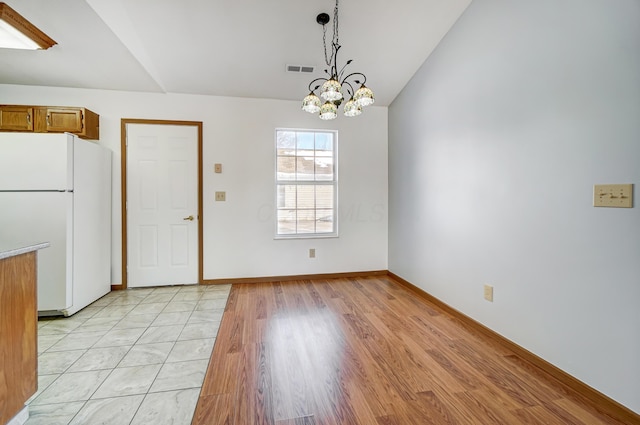 unfurnished dining area featuring light hardwood / wood-style floors and a chandelier