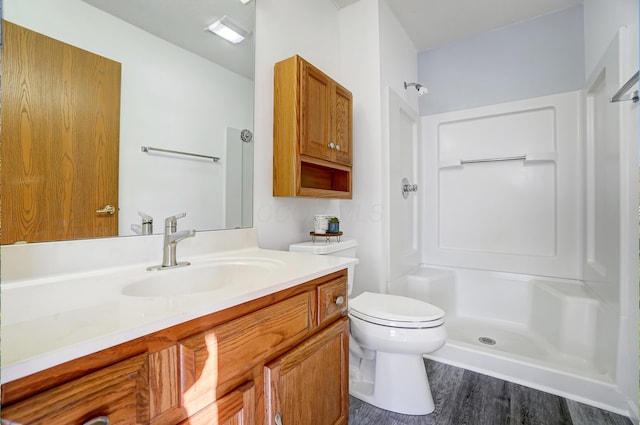 bathroom featuring a shower, wood-type flooring, toilet, and vanity