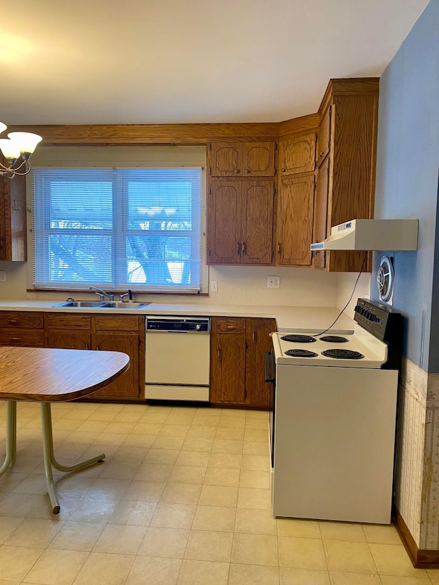 kitchen with white appliances, a notable chandelier, and sink