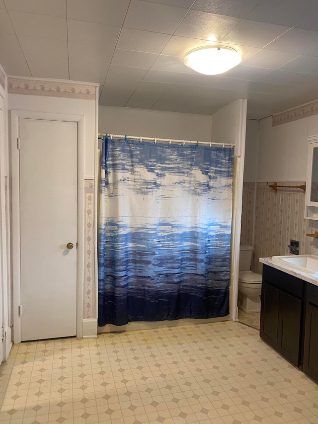 bathroom featuring walk in shower, vanity, and toilet