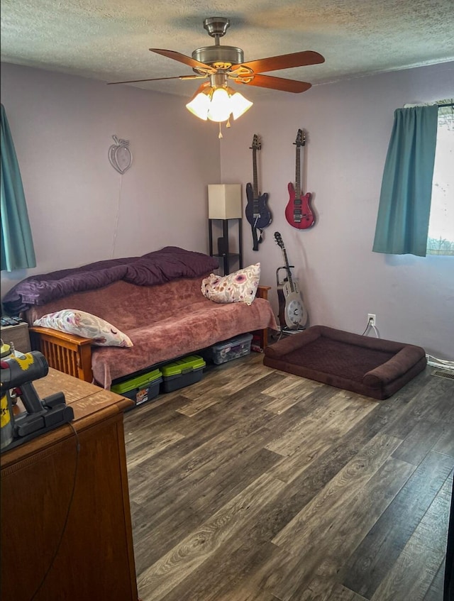 bedroom featuring hardwood / wood-style floors, a textured ceiling, and ceiling fan