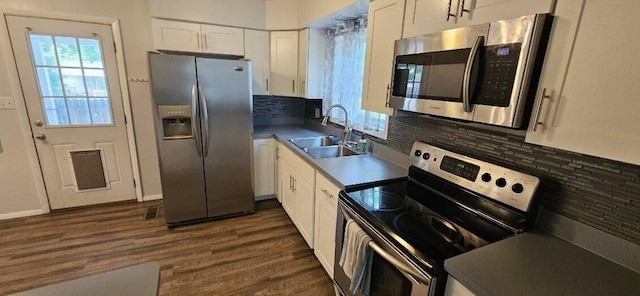 7358 Roshon Ave, Reynoldsburg, OH 43068 - kitchen featuring stainless steel appliances, a sink, white cabinetry, dark wood-style flooring, and tasteful backsplash