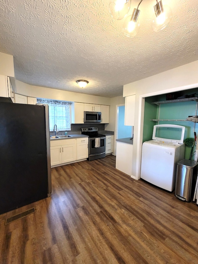 7358 Roshon Ave, Reynoldsburg, OH 43068 - kitchen featuring appliances with stainless steel finishes, dark countertops, white cabinets, dark wood-style flooring, and a sink