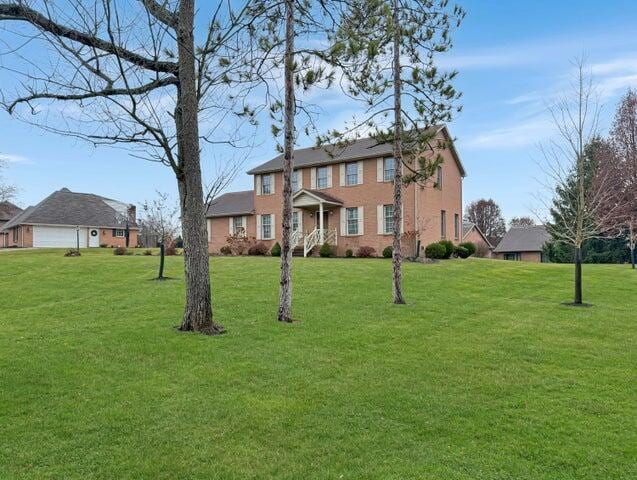 colonial-style house featuring a front lawn