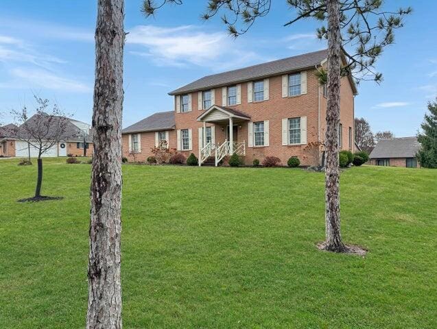 colonial inspired home featuring a front yard