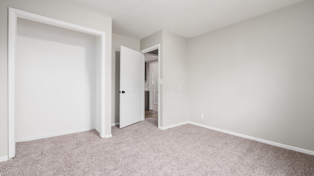 unfurnished bedroom with light carpet and a textured ceiling