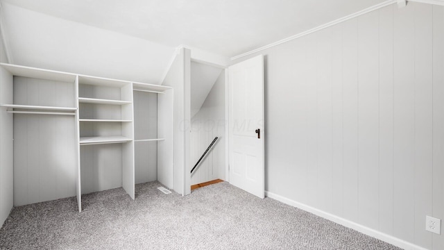 spacious closet with lofted ceiling and light carpet