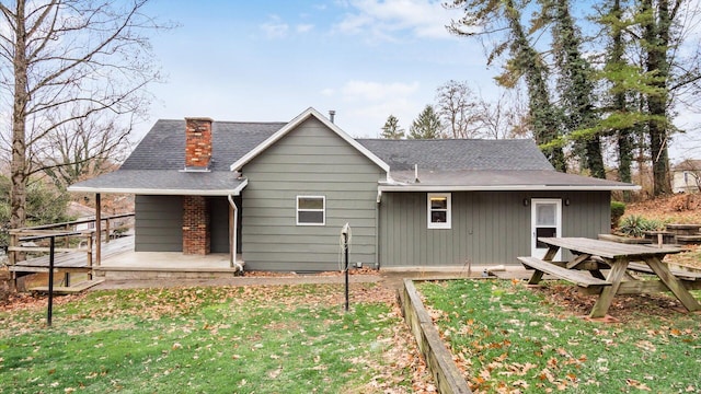 rear view of property featuring a lawn and a wooden deck