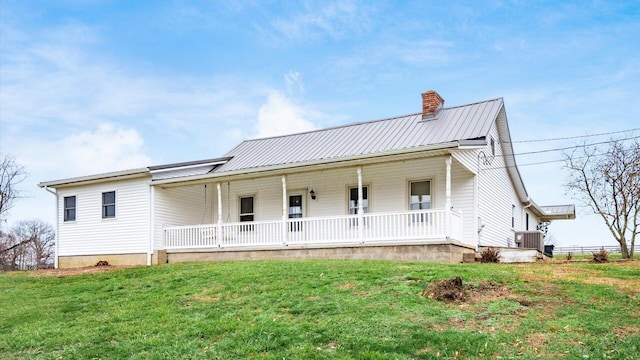 view of front of home with covered porch, central AC unit, and a front lawn