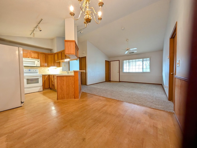 kitchen with kitchen peninsula, decorative backsplash, white appliances, ceiling fan with notable chandelier, and pendant lighting