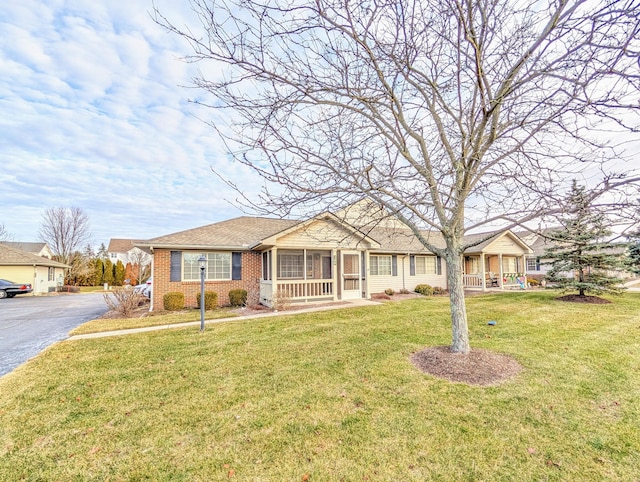 ranch-style house with covered porch and a front lawn