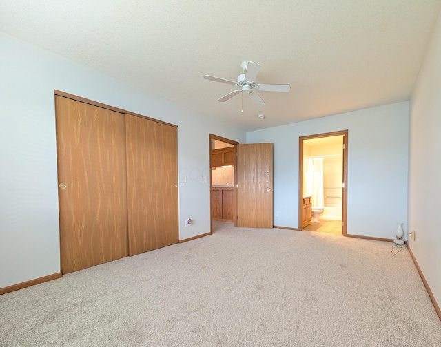 unfurnished bedroom with light carpet, ensuite bathroom, a closet, and ceiling fan