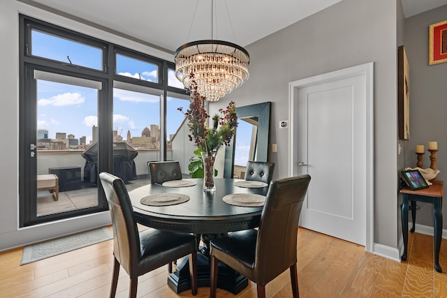 dining area with a chandelier and light hardwood / wood-style flooring