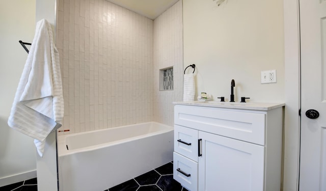 bathroom featuring tile patterned flooring, vanity, and tiled shower / bath