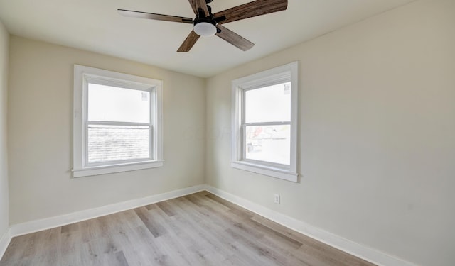 empty room with a wealth of natural light, ceiling fan, and light wood-type flooring