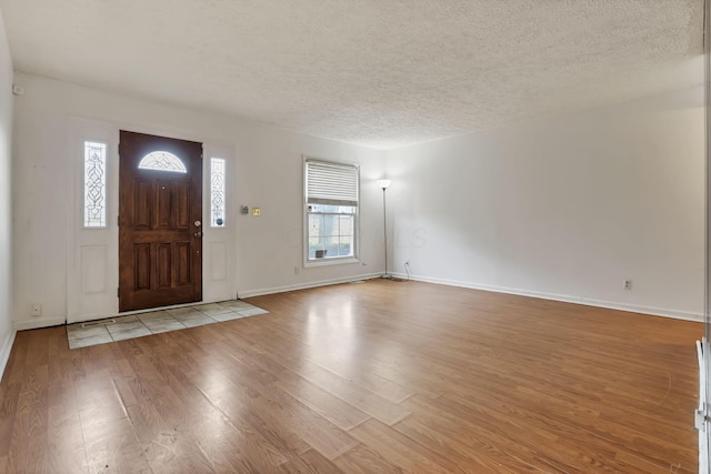 entryway with a textured ceiling and light hardwood / wood-style flooring