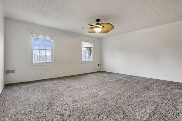 spare room featuring carpet, a textured ceiling, and ceiling fan