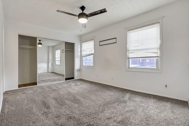 unfurnished bedroom featuring ceiling fan, a closet, and carpet