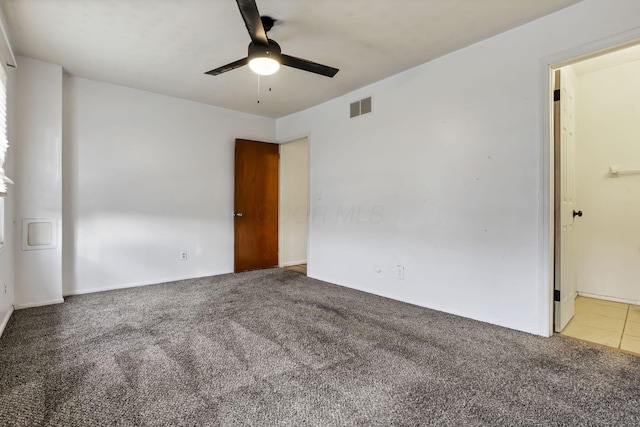 carpeted spare room featuring ceiling fan