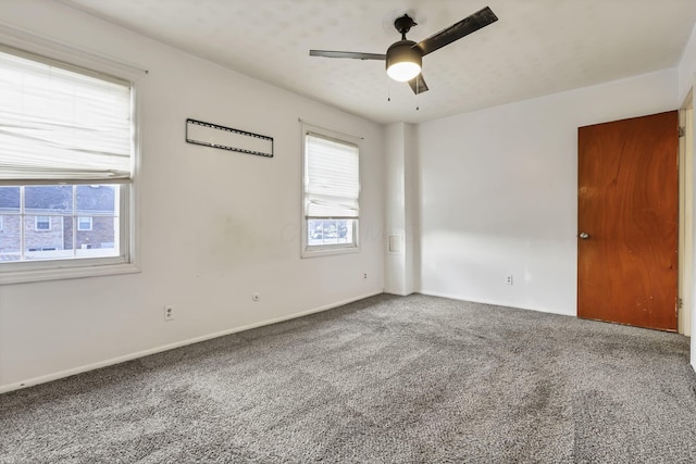 carpeted empty room featuring a wealth of natural light and ceiling fan