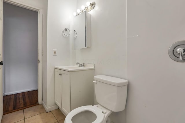 bathroom with toilet, vanity, and tile patterned floors
