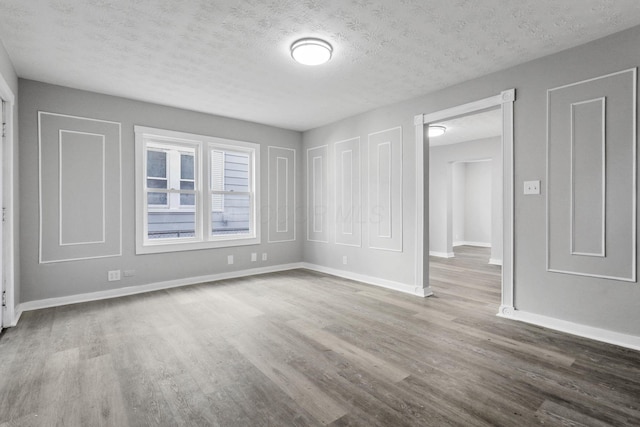 spare room with wood-type flooring and a textured ceiling