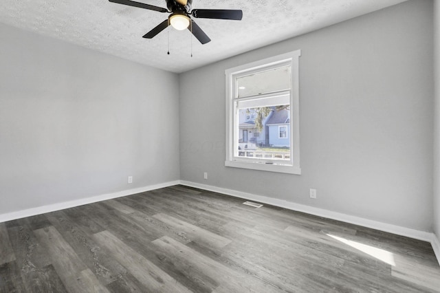 spare room with a textured ceiling, dark hardwood / wood-style floors, and ceiling fan