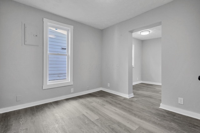 unfurnished room with a textured ceiling and hardwood / wood-style flooring