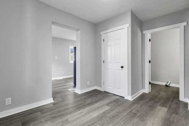 hallway featuring a textured ceiling and dark hardwood / wood-style floors