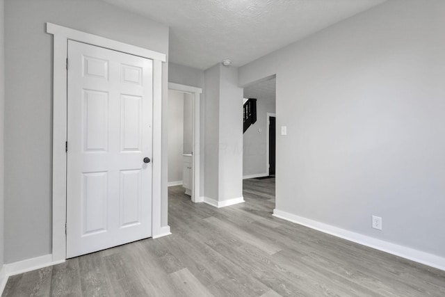 spare room with light hardwood / wood-style flooring and a textured ceiling