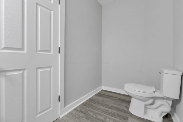 bathroom featuring hardwood / wood-style flooring and toilet