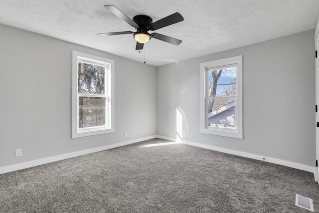 carpeted spare room with ceiling fan and a textured ceiling