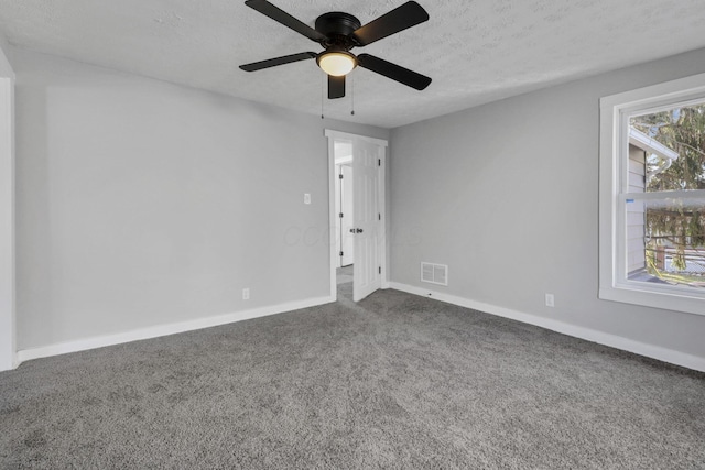 carpeted spare room with ceiling fan and a textured ceiling