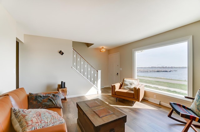 living room with hardwood / wood-style flooring, plenty of natural light, and a water view