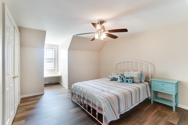 bedroom with ceiling fan, dark wood-type flooring, and vaulted ceiling